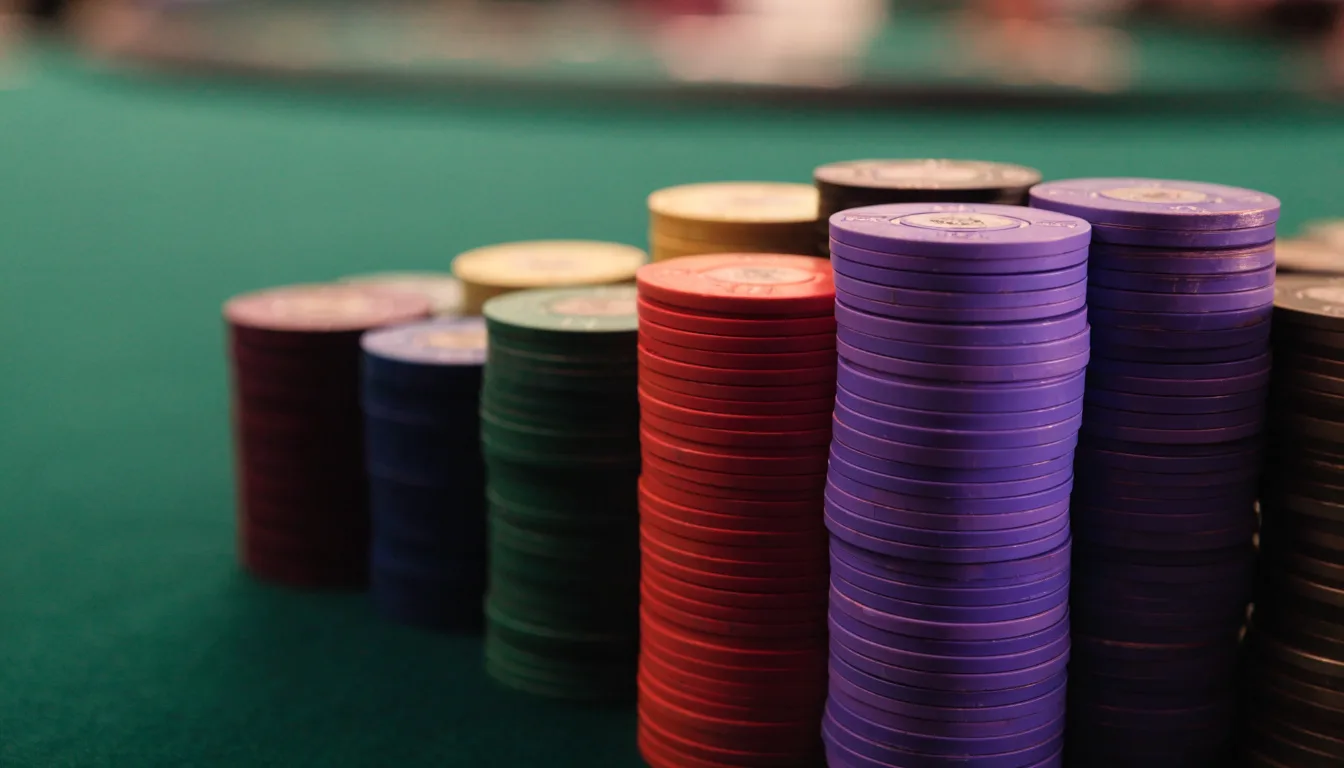 Fichas de casino de varios colores apiladas sobre un tapete verde